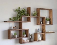 three wooden shelves with plants and rocks on them