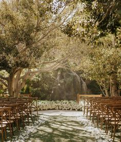 an outdoor ceremony set up with wooden chairs