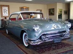 an old car is on display in a museum