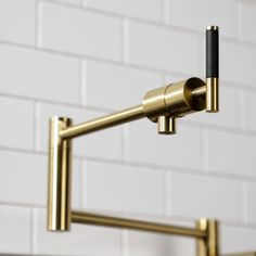 a red and gold faucet in front of a white brick wall