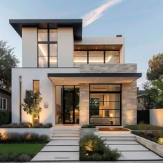 a modern house with large windows and steps leading up to the front door