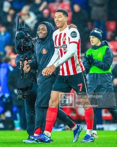 two soccer players are walking on the field with one holding his arm around the other