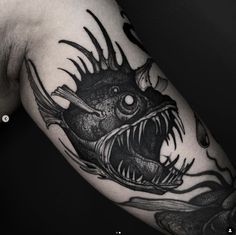 a man's arm with a black and white tattoo design on it, depicting a fish