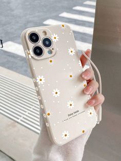 a person holding an iphone case with daisies on it