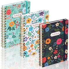 three notebooks with floral designs on them