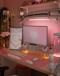 two computer monitors sitting on top of a desk next to pink flowers and other decorations