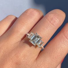 ✦ The Ring Shown in the Picture Holds a Beautiful 1.91 CT Emerald Cut Moissanite. ✦ Main Stone Details✧ Shape: Emerald Cut Moissanite✧ Weight: 1.91 CT (8.50 x 6.50 MM)✧ Color: DEF(Colorless)✧ Clarity: VVS ✦ Side Stone Details✧ Shape: Emerald Cut Moissanite✧ Weight: 1.0 CT (App.)✧ Color: DEF (Colorless)✧ Clarity: VVS ✦ Ring Details ✧ Metal: Gold (10KT, 14KT, 18KT)✧ Metal Tone: Yellow, White, Rose Gold Engagement Rings Sale, Emerald Cut Moissanite, Types Of Diamonds, Bridal Ring Sets, Three Stone Engagement, Moissanite Jewelry, Emerald Engagement, Bridal Bands, Three Stone Engagement Rings