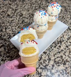 three scoops of ice cream with sprinkles on them sitting on a plate