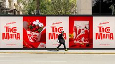 a person walking past a large advertisement on the side of a building with flowers in it