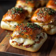 small sandwiches with meat and cheese on a wooden cutting board