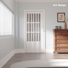 an empty room with a dresser, mirror and pictures on the wall next to it