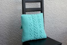 a black chair with a blue pillow on it