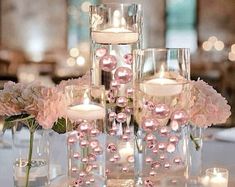 the centerpieces are filled with pink flowers and candles