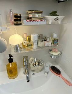 a bathroom sink filled with lots of personal care products and hairbrushes on top of it