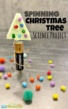 a christmas tree made out of an empty can and some candy on the ground with text overlay reading spinning christmas tree science project