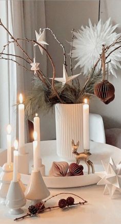 a white table topped with candles and christmas decorations