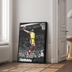 a basketball player dunking the ball in a room with white walls and wood flooring