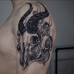 a man's half sleeve with a bull skull and snake tattoo on his arm