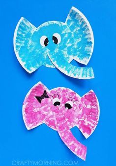 two paper plates shaped like elephants and an elephant with its trunk sticking out, on a blue background