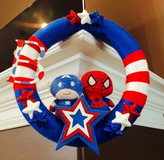 a patriotic wreath with a stuffed animal in the center and a star decoration hanging from it