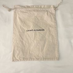 a white bag with the words chinitt & parker on it sitting on a bed