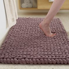 a person standing on top of a pink rug