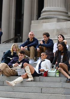 group of people sitting on steps in front of a building