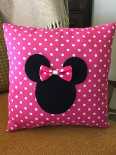 a minnie mouse pillow with a pink bow on it's head and polka dots