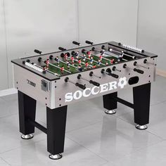 a foosball table sitting on top of a tile floor next to a wall