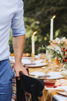 a man standing at the end of a table with plates and napkins on it