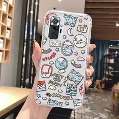 someone holding up their phone case with stickers on it