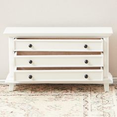 a white dresser sitting on top of a rug