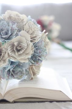 a bouquet of paper flowers sitting on top of an open book