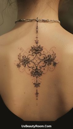 the back of a woman's neck with an intricate cross tattoo on her chest