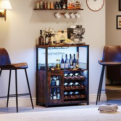 a small bar with several bottles of wine on it and two stools next to it