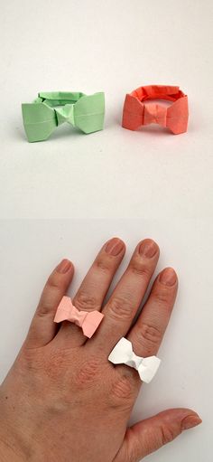 two different types of paper bows on someone's hand, one in pink and the other in green