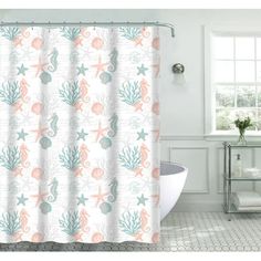 a bathroom with a shower curtain that has shells and starfishs on it