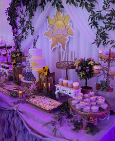 the dessert table is set up with cupcakes, cakes and other food items