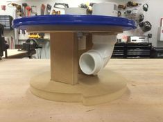 a blue and white object sitting on top of a wooden table in a workshop area