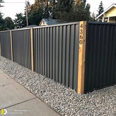 a long metal fence with numbers on the top and bottom posts in front of it