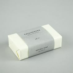 a bar of soap sitting on top of a white table next to a gray wall