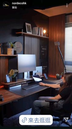 a woman sitting at a desk in front of a computer monitor and keyboard, with the screen turned on