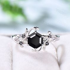 an elegant black diamond ring with leaves on it