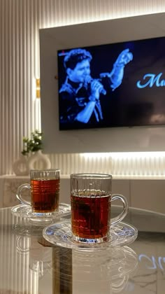 two cups of tea sitting on top of a glass table