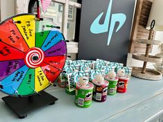 a colorful wheel of fortune sitting on top of a table next to cans of paint