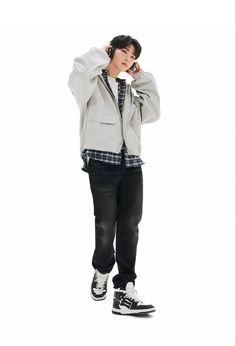 a young man is talking on his cell phone while standing in front of a white background