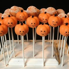 there are many pumpkins on sticks with sprinkles in the shape of faces