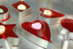 heart shaped candy in tins sitting on top of a table