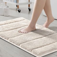 a person walking across a bathroom rug on the floor