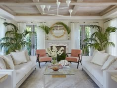 a living room filled with white furniture and lots of windows